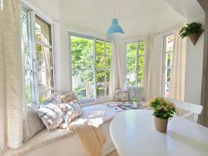 sala de estar con mesa blanca y ventanas en Blue Heaven Guest House Bávaro, Punta Cana, Ideal For Couples, en Punta Cana