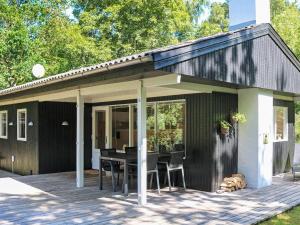 Hadsundにある6 person holiday home in Hadsund-By Traumのデッキにテーブルと椅子が置かれたパティオ