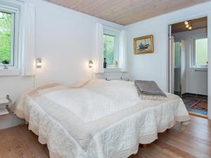 ein weißes Schlafzimmer mit einem großen Bett in der Unterkunft Holiday home Grenaa XLII in Brøndstrup
