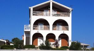 un edificio blanco con balcones en un lateral en Apartments by the sea Sevid, Trogir - 16802, en Marina