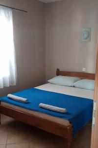 1 dormitorio con cama con sábanas azules y ventana en Apartments by the sea Sevid, Trogir - 16802, en Marina