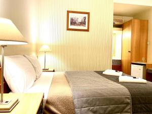 Una habitación de hotel con una cama con dos toallas. en Gateway Motor Inn, en Narrandera