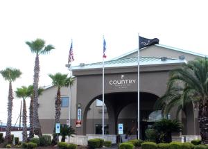 サンアントニオにあるCountry Inn & Suites by Radisson, Lackland AFB San Antonio , TXのヤシの木が目の前に広がる建物