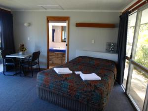 ein Hotelzimmer mit einem Bett und einem Tisch mit Stühlen in der Unterkunft Gayndah A Motel in Gayndah