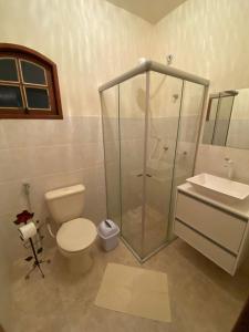 ein Bad mit einer Dusche, einem WC und einem Waschbecken in der Unterkunft Pouso da Olimpia in Tiradentes