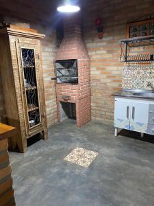 ein Backsteinzimmer mit einem Steinofen und einer Ziegelwand in der Unterkunft Pouso da Olimpia in Tiradentes