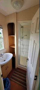 a small bathroom with a sink and a shower at Duży domek Holenderski 40m2 grill in Kępiny Wielkie