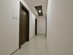 a hallway with black doors and white walls at HOTEL SRIRAMA INN in Gachibowli