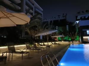 a pool with chairs and umbrellas next to a building at Sheraton ocean 603 - Without Pool access in Cairo