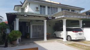 a white car parked in front of a house at RR Homestay Lot 144 Chukai Kemaman in Cukai