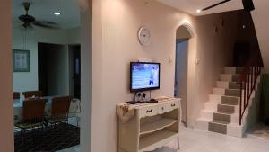 a living room with a tv on a wall at RR Homestay Lot 144 Chukai Kemaman in Cukai