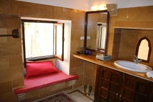 een badkamer met een rode bank naast een wastafel bij Killa Bhawan in Jaisalmer