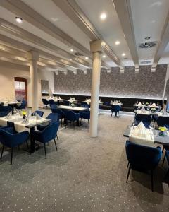 uma sala de jantar com mesas e cadeiras azuis em Hotel U Královny Elišky em Hradec Králové