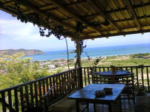 balcón con 2 mesas y vistas al océano en Maremonti Vacation Rental, en Puerto López