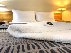 a bed with a white towel on top of it at Gateway Motor Inn in Narrandera