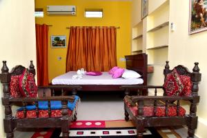 a bedroom with a bed and two chairs at Hotel Moon Light in Pushkar