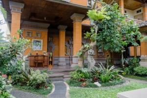 ウブドにあるデサク プトゥ プテラ ホーム ステイの木々と植物が目の前にある家