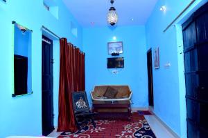 a blue room with a chair and a red curtain at Hotel Moon Light in Pushkar