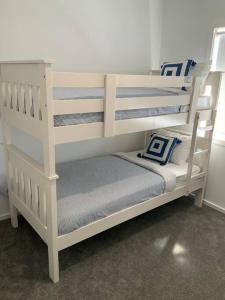 a white bunk bed with a blue and white pillow at METUNG 3 BEDROOM New House in Metung