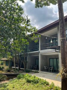 ein Haus mit einem Balkon und Stühlen davor in der Unterkunft Blues River Resort in Chao Lao Beach