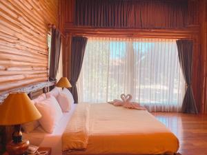 a bedroom with a bed and a large window at Blues River Resort in Chao Lao Beach