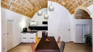 a kitchen and dining room with a table and chairs at Casa Minerva - Suite e Relax in Gioia del Colle