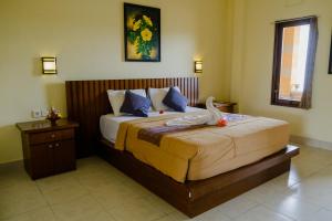 a bedroom with a bed with a swan on it at Desak Putu Putra Home Stay in Ubud