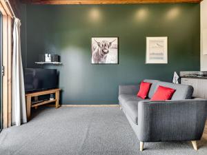 a living room with a couch and a tv at Shining Star Beachfront Accommodation in Hokitika