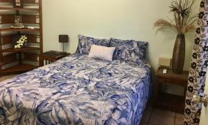 a bedroom with a bed with a blue comforter at Palmerston Sunset Retreat in Palmerston