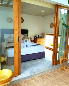 a bedroom with a bed and a glass door at The Edicha in Lovina