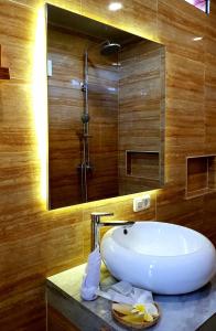 La salle de bains est pourvue d'un lavabo blanc et d'un miroir. dans l'établissement The Edicha, à Lovina