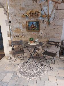 - une table et des chaises dans une pièce dotée d'un mur en pierre dans l'établissement Ferienwohnung Zu den Weinbergen, à Zeil