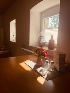 una mesa con un jarrón de flores y una ventana en Ferienwohnung Zu den Weinbergen en Zeil