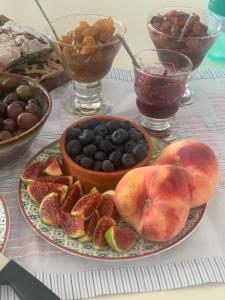 una mesa con una bandeja de fruta y un tazón de bayas en B&B LUCHICHI en Igalo