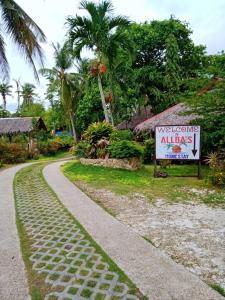 a winding road with a sign next to a resort at Allba's Homestay in Moalboal