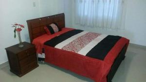 1 dormitorio con 1 cama grande y mesita de noche en Conjunto Habitacional EspinBarroso, en Puyo