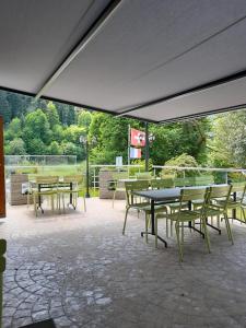 a patio with tables and chairs under a canopy at Soubey (Clairbief) in Soubey