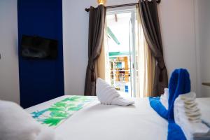 拉斯杜環礁的住宿－棕櫚樹旅館，一间卧室,床上有蓝色鞋