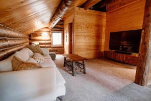 a living room with a couch and a flat screen tv at Classic Log Cabin near Rocky Mountain National Park and near Skiing in Lyons