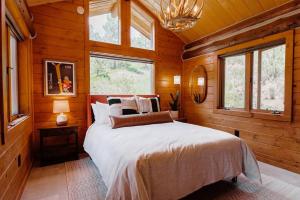 a bedroom with a bed in a wooden cabin at Classic Log Cabin near Rocky Mountain National Park and near Skiing in Lyons
