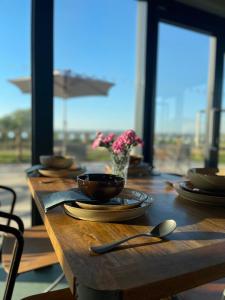 een houten tafel met borden, kommen en keukengerei erop bij Middlewick Holiday Cottages in Glastonbury