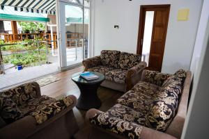 拉斯杜環礁的住宿－棕櫚樹旅館，客厅配有两张沙发和一张桌子