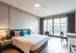 a hotel room with a large bed with blue pillows at Laguna Grand Hotel & Spa Songkhla in Songkhla