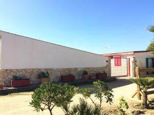 a white building with plants in front of it at Agriturismo Eolo in Taranto