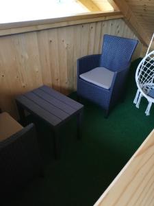 a porch with a table and two chairs and a table and a bench at Soba pri Bregarju in Bohinj