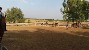 a group of people riding horses on a dirt track at Agriturismo Eolo in Taranto