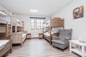 a dorm room with bunk beds and a chair at Basecamp Frich`s Hjerkinn in Hjerkinn