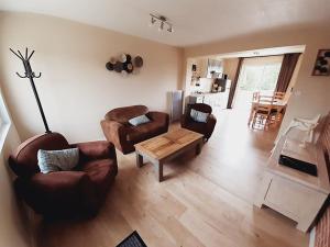 a living room with two couches and a coffee table at Le domaine des biches in Longueville