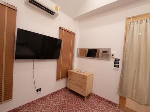 Pokój z telewizorem z płaskim ekranem na ścianie w obiekcie RIM HuaHin Villa By RoomQuest w mieście Hua Hin