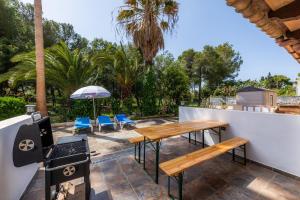 een patio met een tafel en stoelen en een parasol bij Dolce Vita in Alcudia